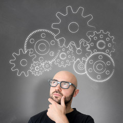 Gear wheel going out of the head of a young attractive smiling m