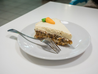 Picture of the cake on the white plate close up. Side view of the cake with fork on white background.