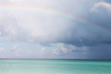 Морской пейзаж - яркое лазурное Карибское море, кучевые облака и радуга. Фото сделано на Кубе.
