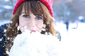 Pretty young girl blowing snow