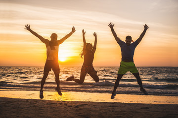 Group of people doing exercises at the beach.