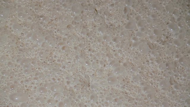 The fermentation process of yeast at the factory for baking bread. Fermentation of yeast ferment close-up at the factory. Yeast bubbles. Bread Factory.
