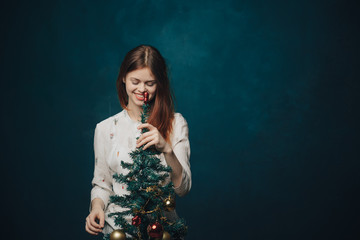 woman dresses up a Christmas tree for a holiday