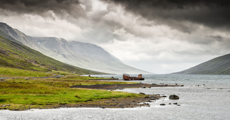 Mjoifjordur, Iceland - Panorama of fishing boat wreck rusting in