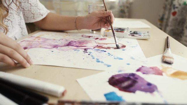 Painting with watercolors. On a white sheet of paper. Female hand artist. The lessons of modern painting. School of the Arts. Lesson fine art