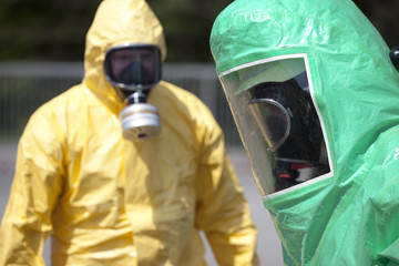 Two men in protective gear cleaning up after chemical accident