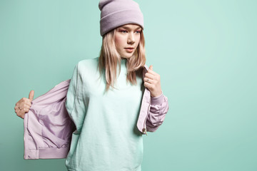 Fashion girl in blank sweatshirt jacket takes on a blue background in pastel colors