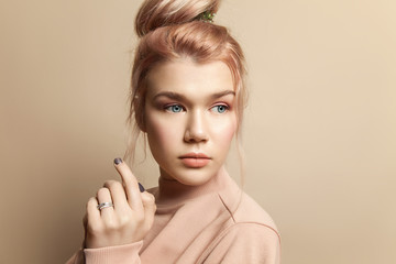 Portrait of a beautiful young woman in soft powdery beige pastel colors with natural make-up