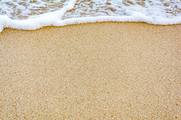 Fototapeta na wymiar Waves crashing into the sand