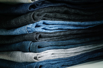 Lots of jeans stacked in the darkness