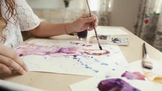 Artist painting in her studio with water colors