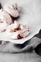 Homemade french meringue on white baking paper with gray towel