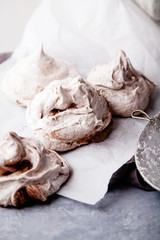 Three homemade french meringues on white baking paper with towel