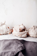 Homemade french meringue on white baking paper with gray towel