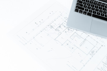 notebook over house construction blueprint with blue tone effect