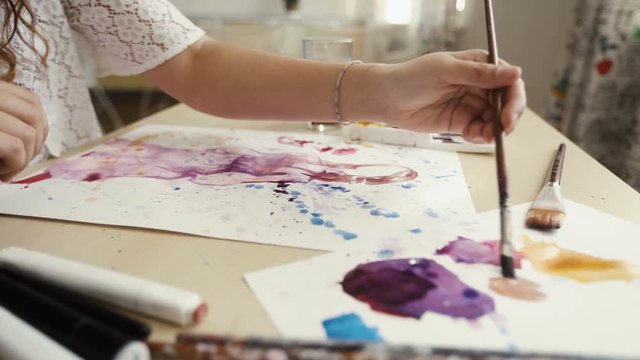 young woman artist mixing paint while working