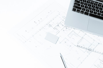 Pen, drawing rulers, and notebook over house construction bluepr