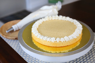 Cake in process on stand on wooden table, Homemade Cake.