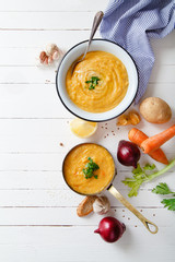 Roasted pumpkin and carrot soup on white wooden background. Copy space. Vegetarian concept