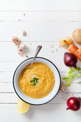 Roasted pumpkin and carrot soup on white wooden background. Copy space. Vegetarian concept