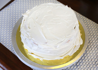 Cake in process on stand on wooden table, Homemade Cake.