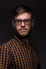 Obraz premium man with a beard wearing glasses on black background. large portrait
