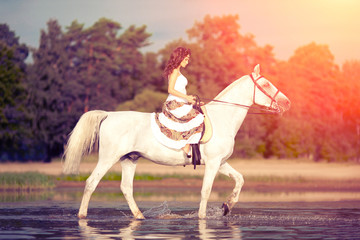 Fototapeta na wymiar Young woman on a horse. Horseback rider, woman riding horse on b