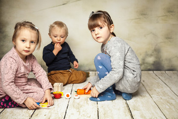 drei Kinder spielen zusammen mit Obst