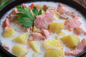 Salmon soup with cream, potatoes, parsley