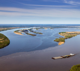 Pusher ship with barge on spring river, top view