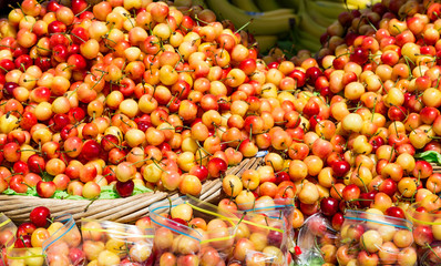 Fresh Cherries in Baskets and Bags at Market