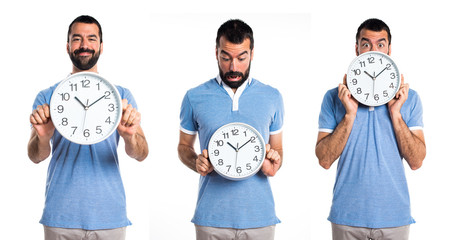 Man with blue shirt holding clock