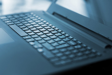 Angled photo of black laptop keyboard, with lights