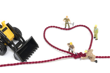 Miniature worker team building Heart Shaped with rope on white background © Sirichai Puangsuwan
