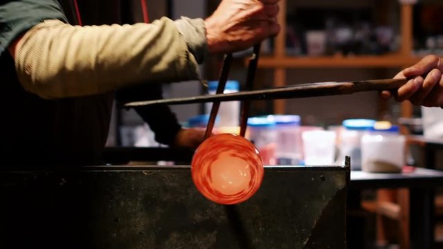 Team of glassblowers shaping a molten glass
