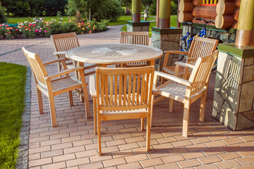 Chairs and glass table on brick terrace at countryside
