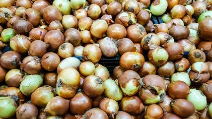 Group of dried organic onions in a marketplace