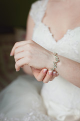 Obraz na płótnie Canvas Bride's hands with simple manicure buttons bracelet