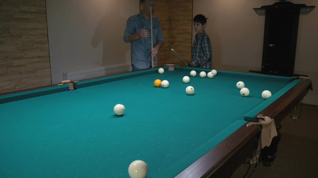 Russian billiards. Father teaches son to play pool