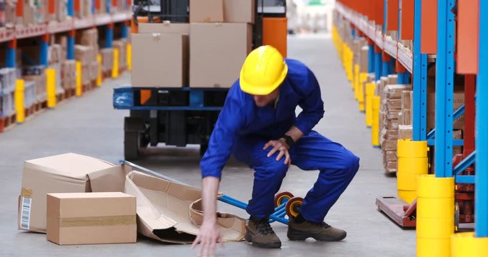 Male warehouse worker falling while working