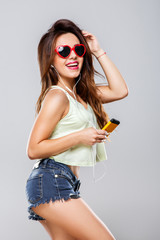 Girl in heart-shaped sunglasses holding MP3 player