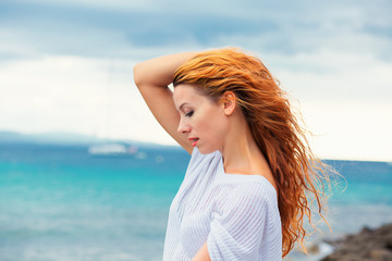 Fototapeta na wymiar beautiful young woman on the beach, enjoying nature watching the sunset