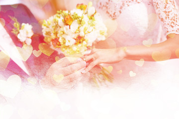 Groom puts wedding ring on brides finger, valentine background 
