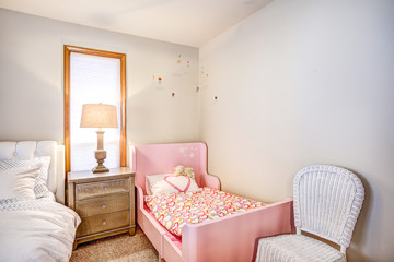Shared master bedroom interior with girl's pink bed