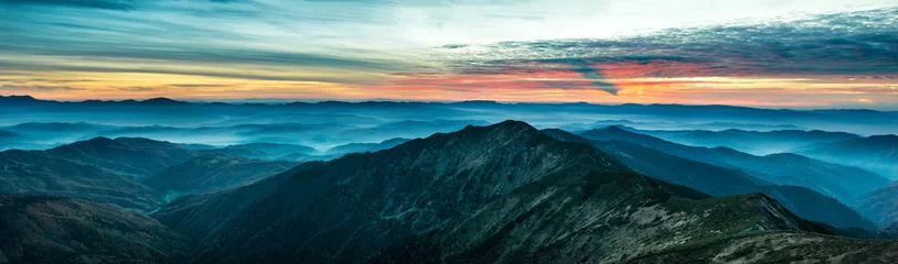 Foto op Canvas Panorama met blauwe bergen en heuvels bij zonsondergang © Pavlo Vakhrushev