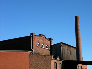 Schöne nostalgisch anmutende alte Fabrik mit Gebäude mit Backsteinfassade und Schornstein vor strahlend blauem Himmel in Sonnenschein in Gütersloh in Ostwestfalen-Lippe