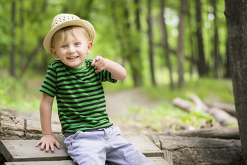 Young boy sitting on a log pointing