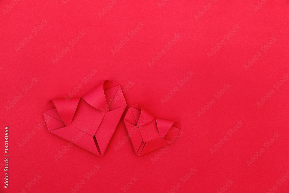 Poster two folding red paper hearts on red for pattern and background