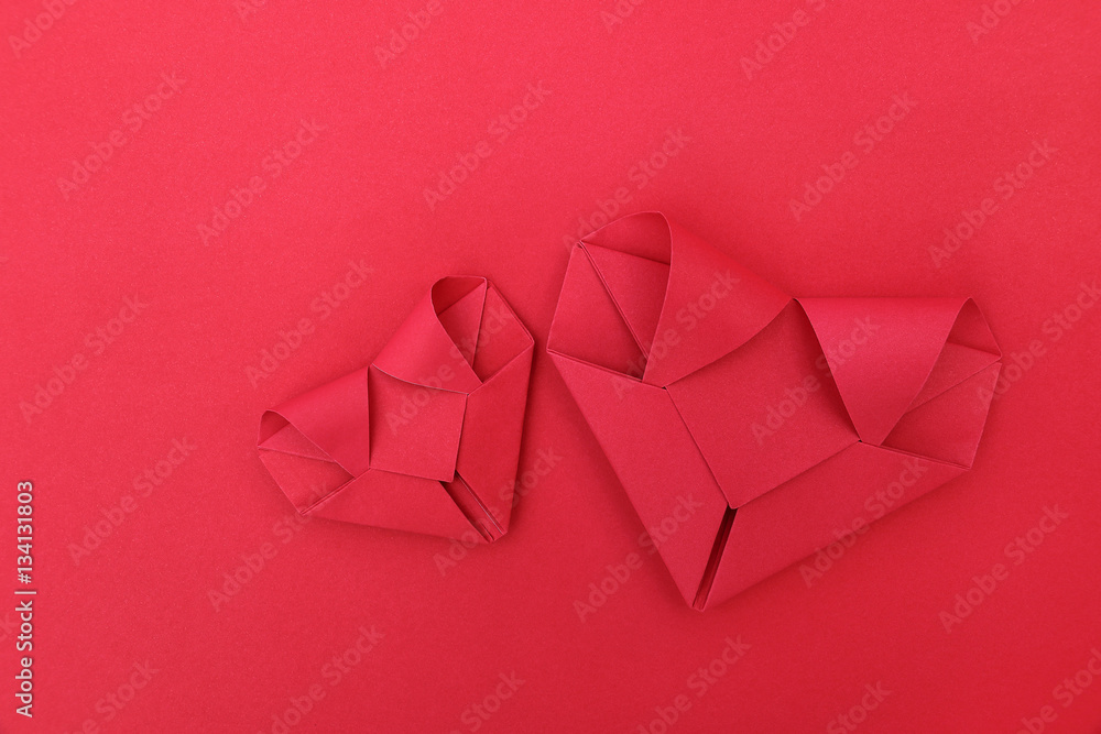 Poster two folding red paper hearts on red for pattern and background