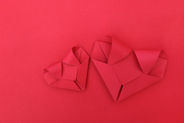 two folding red paper hearts on red for pattern and background